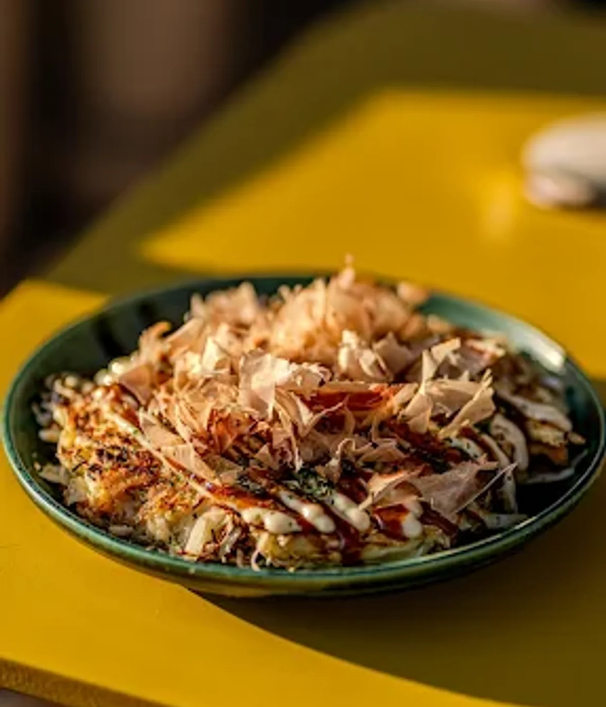 Okonomiyaki servi chez Subaco, katsuobushi et sauces